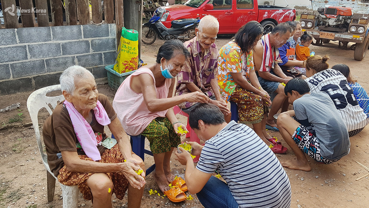 송끄란의 중요한 의식중에 하나로 가족내 어른의 손과 발에 물을 부어주며 경의를 나타내는 의식을 하고 있다.