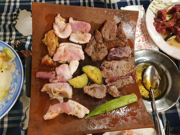 황토로 만든 기왓장에 돼지고기와 말고기를 반반씩 올린다. @뉴스코리아 이웅연 특파원 