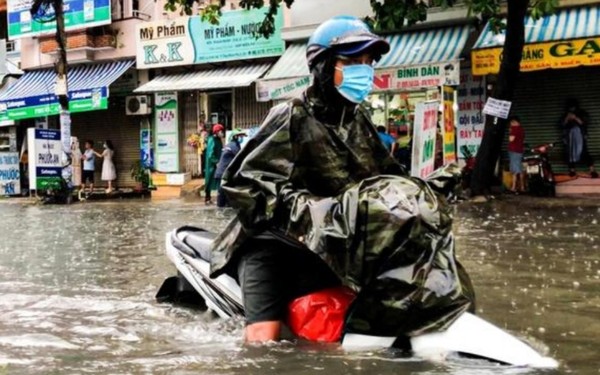 호치민시 빈탄군의 25일 침수된 도로를 한여성 운전자가 지나가고 있다.  @뉴스코리아 이웅연 특파원