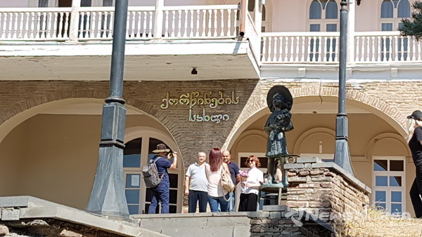 뒷편 건물이 결혼을 하면 서명을 하는 결혼 등기소와 피로스마니의 그림 중 엄마 모자와 목걸이 신발을 싣고 있는 소녀 동상 @뉴스코리아 박철호 특파원