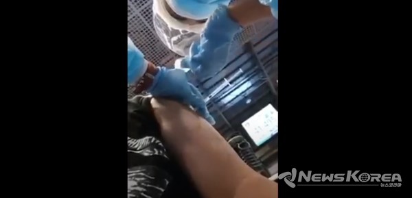 논란의 백신 접종 영상, 백신이 들어있는 피스톤을 누르지 않은 채 접종 위치에 반창고를 붙이기 위해 준비를 하고 있다 @뉴스코리아 (사진:SNS 영상 캡쳐)