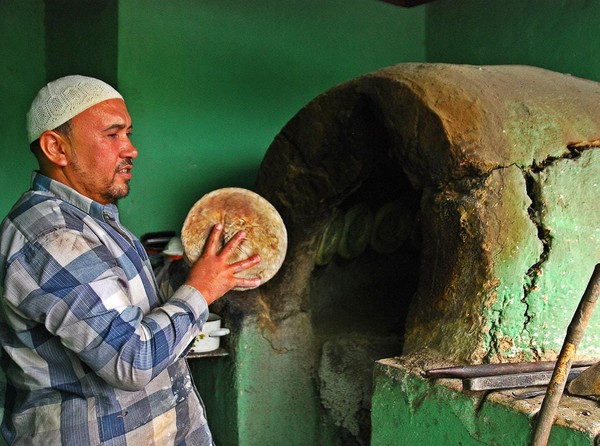 ▲사진 : 키르기스 전통 화덕에 리뾰쉬까를 만드는 모습