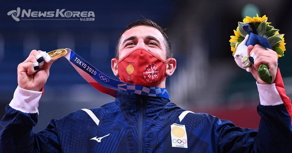 라샤 베카우리가 도쿄에서 열린 남자 유도 90kg급 결승에서 금메달을 목에 걸고 환호하고 있다. @사진: 조지아 올림픽 위원회