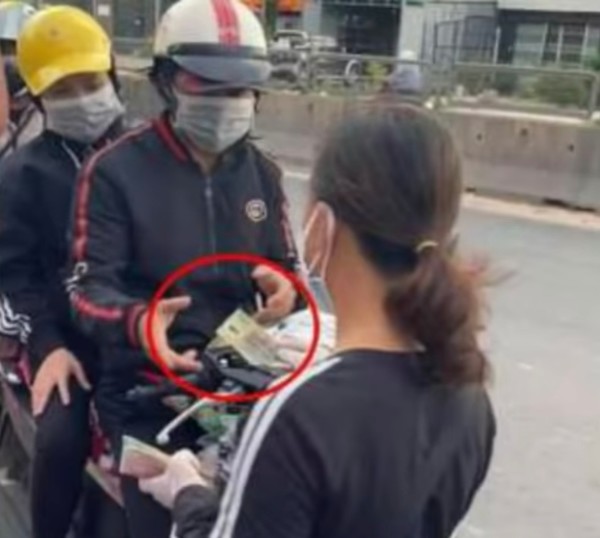 쩐후에 씨가 일자리를 잃고 고향으로 귀향하는 사람들에게 여비에 보태 쓰라고 돈을 나눠주고 있다. @뉴스코리아 이웅연 특파원 