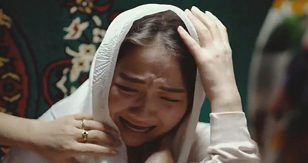 결혼한 여자라는 표식의 머리수건을 강제로 씌움 당하고 우는 납치 당한 처녀 (영화의 한 장면)