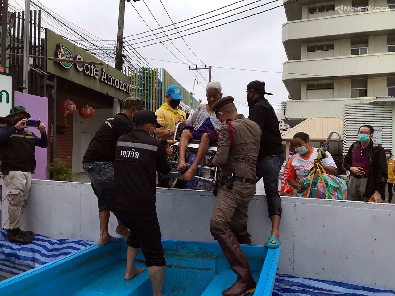경찰이 거동이 불편한 노인을 침수 현장에서 안전한 곳으로 대피 시키고 있다. / 사진 : 태국 경찰