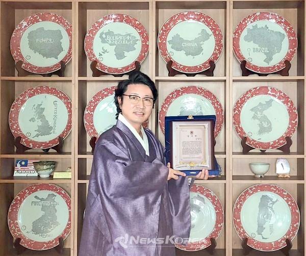 한한국 세계평화작가가 주캄보디아대한민국대사관 박흥경 대사감사패를 받고 기념촬영을 하고 있다. @사진제공=한한국 세계평화작가