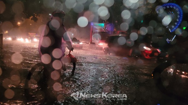 오후 7시경 불어날 물길을 시민이 자전거로 위험 천만한 주행을 하고 있다. @뉴스코리아 최신 특파원