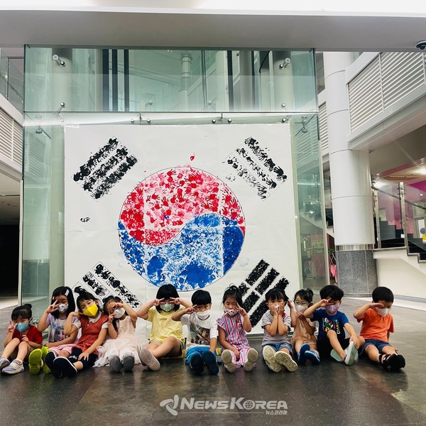 남서울대학교 부설 어린이집에 대형한지 태극기앞에서 아이들이 기념사진을 찍고 있다. @뉴스코리아 웬칸리 기자