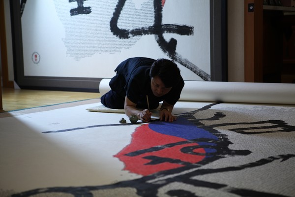 무릎을 꿇고 '희망대한민국'을 작업 중인 한한국 작가 @작가 제공