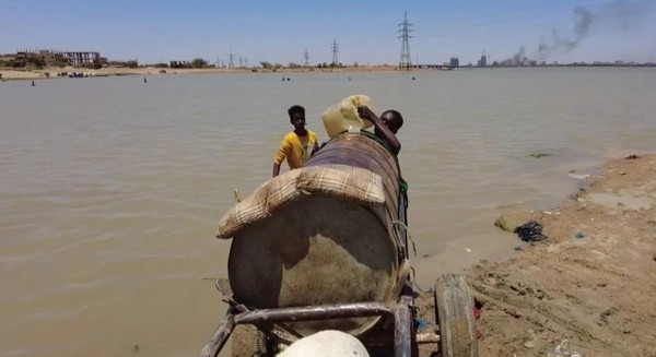 사진은 양동이에 물을 모아 운반하기 위해 바퀴가 달린 임시 카트를 사용하는 모습을 담고 있다.  @BBC News 캡쳐