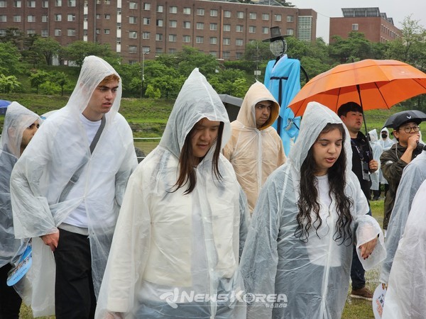 퍼레이드에 참가한 외국인 참가자들이 우비를 입고 행진하고 있다. @뉴스코리아 최신 기자