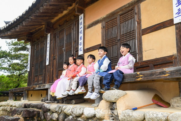 축제기간 선비촌을 찾은 아이들이 비를 비해 처마밑에 앉아있다. @뉴스코리아 최신 기자
