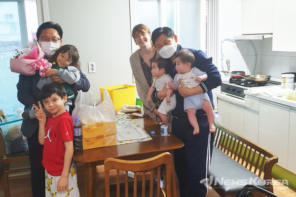 임시주거시설에 입주한 최민웅씨 자녀의 유치원 수료를 기념해 조원1동 주민단체가 마련한 꽃다발과 통닭 등 깜짝 선물을 전달하고 있다. @수원시