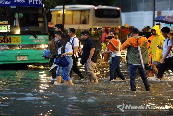 마닐라 태프트 애비뉴와 유엔 애비뉴의 폭우로 침수된 모퉁이를 걸어가고 있는 마닐라 시민들. @PNA 제공