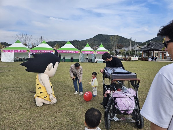  원시인 인형과 시민들이 사진을 찍고 있다.  @뉴스코리아 김여진 기자
