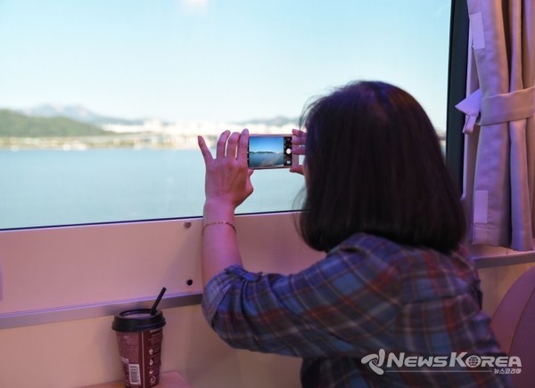 참가자가 차창밖 풍경을 스마트폰 카메라에 담고 있다. @뉴스코리아 백요훈 기자