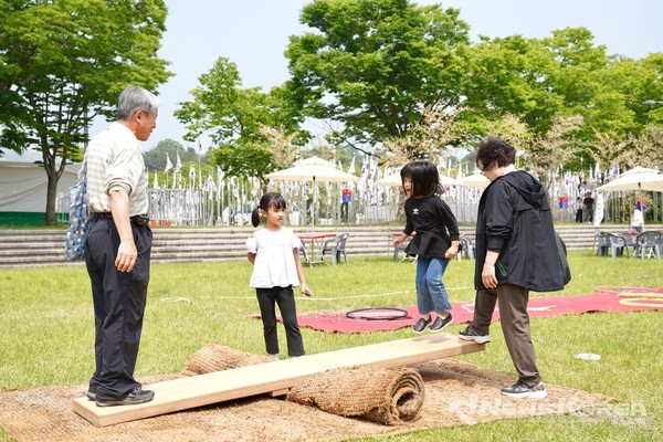레이나씨와 자녀들이 널뛰기 체험을 하고 있다. @뉴스코리아 최신 기자