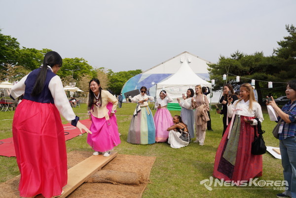 외국인 인플루언서들이 널뛰기 체험을 하며 즐거워 하고 있다. @천안시