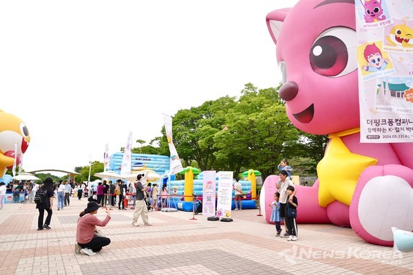 대형 핑크퐁 모형 앞에서 자녀들과 동행한 보호자들이 함께 기념촬영을 하고 있다. @천안시