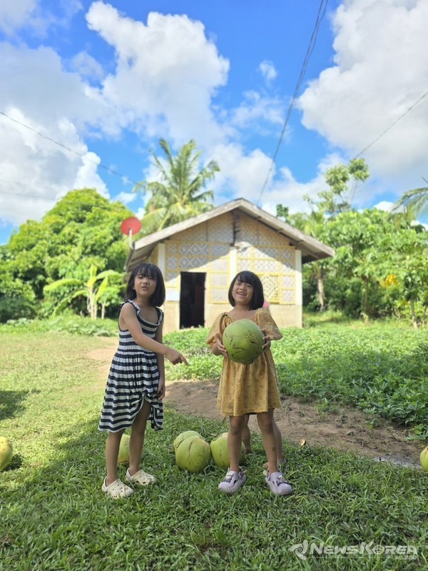 코코넛 열매를 들어 올리며 기뻐하고 있는 보홀을 찾은 아이들으 모습 @뉴스코리아 최신 특파원