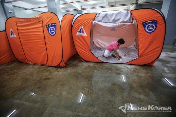 퀘손시티의 상습 홍수 위험지역인 바랑가이 바공 실랑간 대피센터에서는 태풍 페피토의 피해에 대비해 식량팩과 의약품등이 구비된 수재민 수용 텐트를 점검하고 있다. @PNA