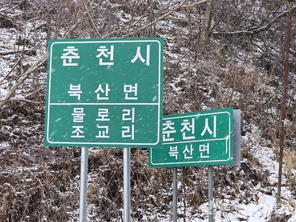 홍천군에서 재를 하나 넘자 산정상에 춘천시 북산면이라는 이정표가 보인다. @뉴스코리아 최신 기자