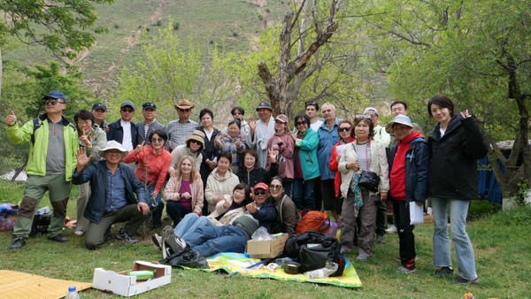 ▲법회와 자연보호 활동을 마친 후, 자은사 신도들이 쑥곡 계곡에서 함께 기념 촬영을 하고 있다. 한국인과 현지인이 함께한 이번 행사에는 약 40여 명이 참여해 따뜻한 교류의 장이 되었다. @뉴스코리아 신현권 특파원