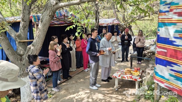 ▲우즈베키스탄 타슈켄트주 쑥곡 계곡에서 열린 자은사의 정기 일요법회. 조주 스님이 법문을 낭독하는 가운데, 한국 및 현지 신도들이 합장하며 법회에 동참하고 있다. 이날 법회는 자연보호와 불교 포교를 겸해 야외에서 진행되었다. @뉴스코리아 신현권 특파원