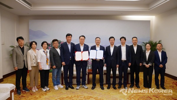 천태현 초청 서한문 교환 : 구복규 화순군수와 천천 천태현 당서기가 대표 축제 초청 서한문을 서로 교환하고 기념 포즈를 취한 모습(중앙에 운동화 신은이가 구복규 화순군수) @화순군