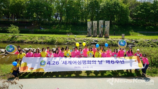 IWPG 관계자들이 양재천 수변 무대 옆에서 4.26 세계여성평화의 날을 기념하고 있다. @IWPG