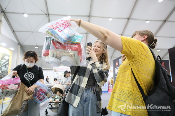 지난 5일 문화체육관광부 K-인플루언서, 코리아넷 명예기자단이 ‘2025 천안 K-컬처박람회’ 푸드 산업전시관에서 비빔라면 등을 구매하고 기념촬영을 하고 있다. @천안시