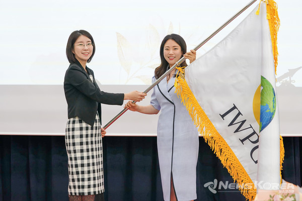㈔세계여성평화그룹(IWPG) 전나영 신임 대표가 1일 서울 스페이스쉐어 서울중부센터에서 열린 대표이사 이·취임식에서 윤현숙 전 대표로부터 깃발을 전달받고 있다. @IWPG