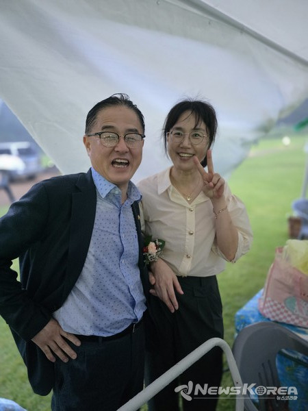 행사 관계자들의 텐트를 찾은 비에 젖은 장혀 의원과 비를 맞지 않은 지역민이 활짝 웃으며 사진촬영을 하고 있는 모습이 대조적이다. @뉴스코리아 최신 기자