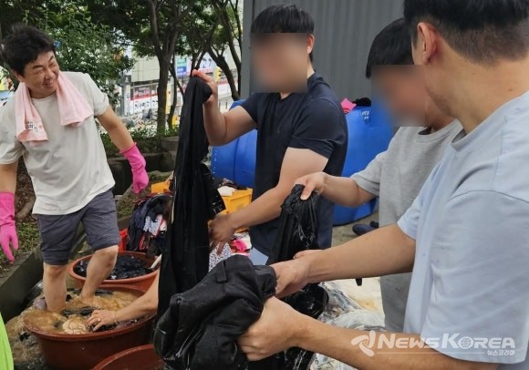 김철환 천안시의원(왼쪽)이 자원봉사자들과 함께 폭우로 침수 피해를 입은 성환지역 주민들의 젖은 옷을 세탁하며 복구 지원에 나서고 있다. @김철환 의원실