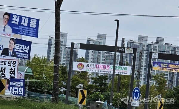 사진 왼쪽 도로변에 내걸린 불법 현수막들과 오른쪽에 텅 비어 있는 공공 게시대가 무색해 보인다. @뉴스코리아 최신 기자