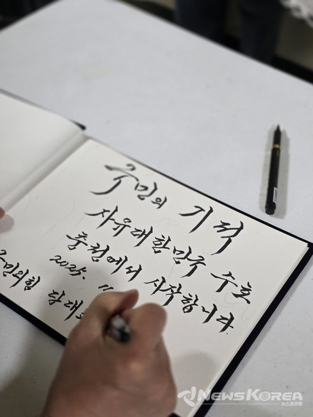 장동혁 국민의힘 대표가 방명록에 '국민의 기적 자유대한민국 수호 충청에서 시작합니다'라고 적고 있다. @뉴스코리아 최신 기자