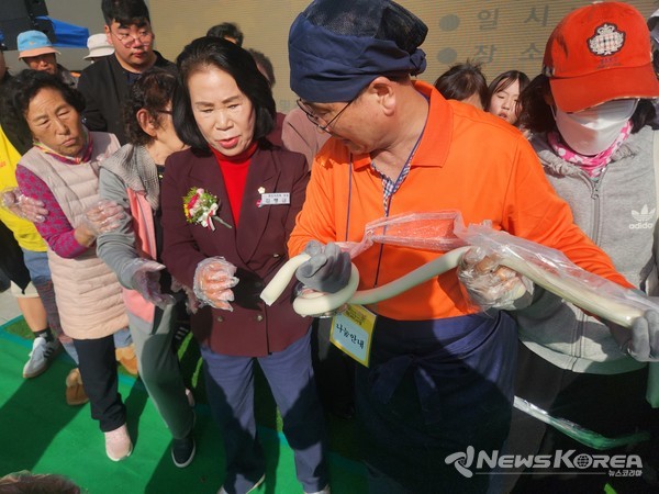 김행금 의장이 시민들과 함께 가래떡 길게 뽑기 체험을 즐기고 있는 모습. @뉴스코리아 김현미 기자 