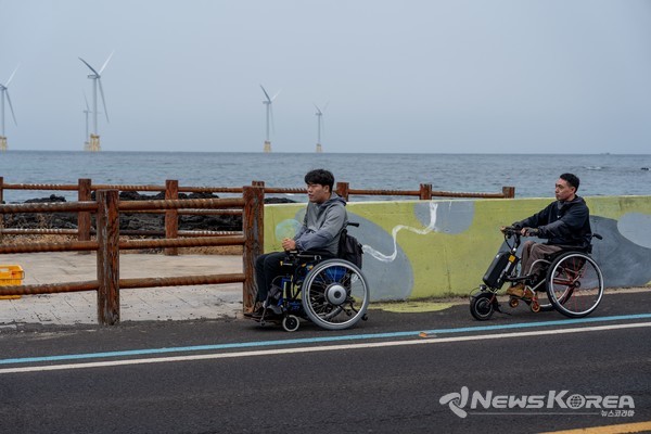 [제주드림런 휠체어 참가자] 무장애 여행을 상징하는 휠체어 러너 전성환 대표가 성산 해안도로를 달리고 있다. @제주관광공사