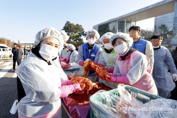 공무원 노사와 천안시행복키움지원단이 겨울맞이 사랑이 김장나눔 행사 현장에서 김행금 천안시의회 의장과 김석필 천안시장 권한대행 부시장이 직접 김치를 담그고 있다. @뉴스코리아 최신 기자