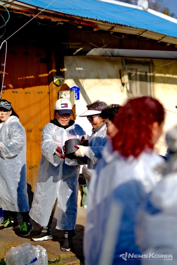“이른 추위 속에서도 봉사자들이 구슬땀을 흘리며 연탄을 옮기고 있다.” @뉴스코리아 최신 기자