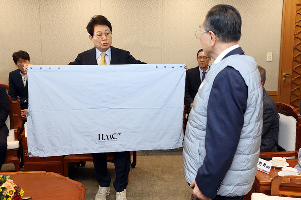 기부된 반사광 교통안전망토를 참석자들에게 소개하고 있다. @충청남도