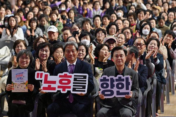 행사에 참석한 장기요양요원들과 주요 내빈이 ‘노후를 향한 행복한 동행’ 문구가 적힌 피켓을 들고 기념촬영을 하고 있다. @충청남도